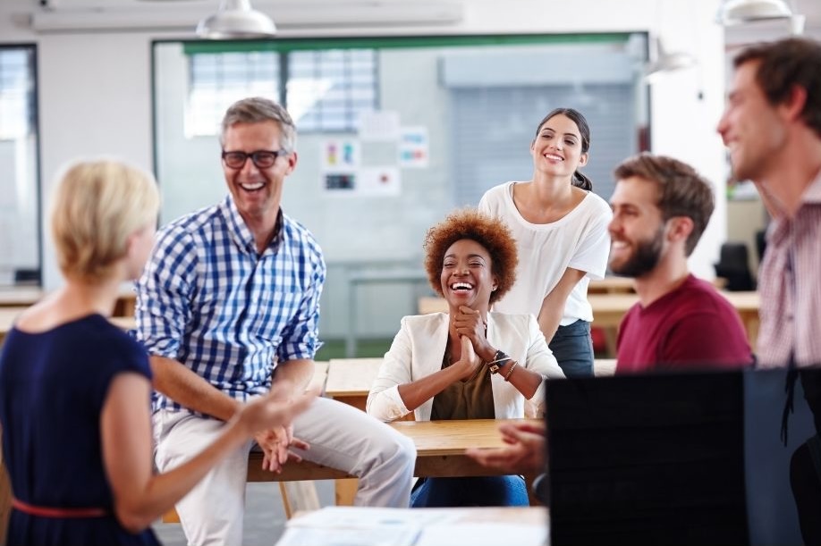 A group of smiling people gather as a group to develop new skills.