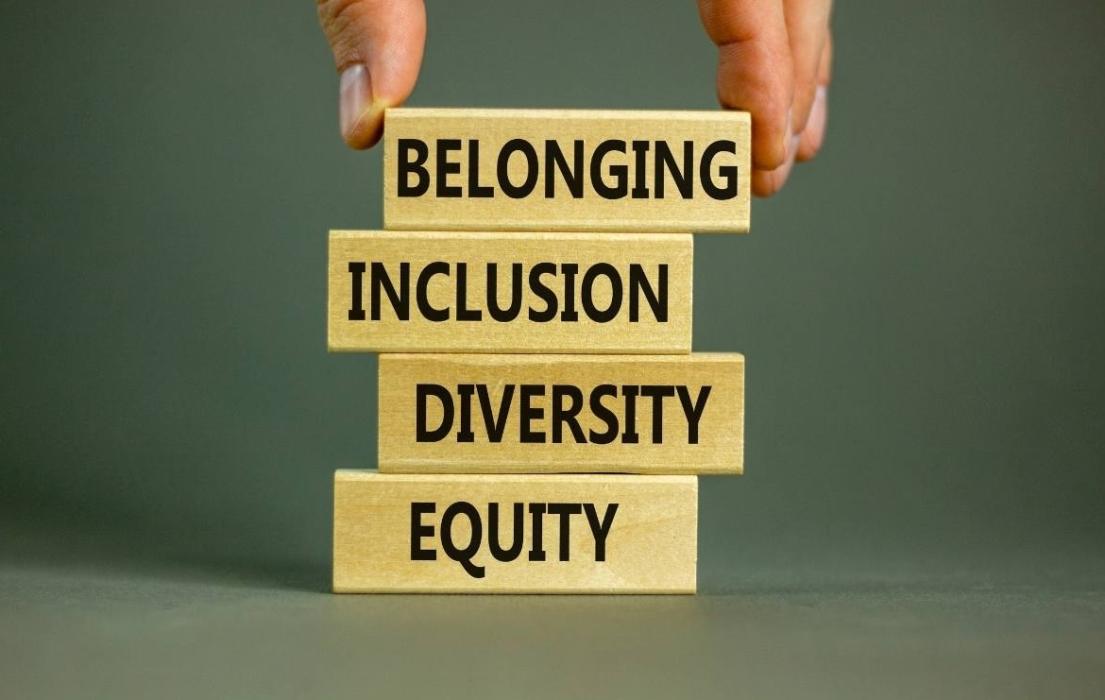 Four building blocks are piled on top of one another. Each says a word: Equity, diversity, inclusion, belonging.