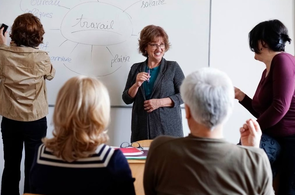 A group of engaged learners gather around a dynamic facilitator.