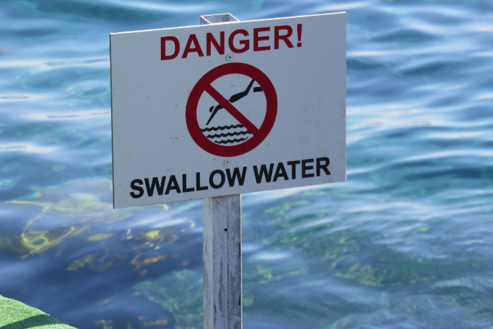 A "Danger Shallow Water" sign in the water.