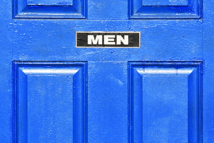 A blue door with the word men on it.