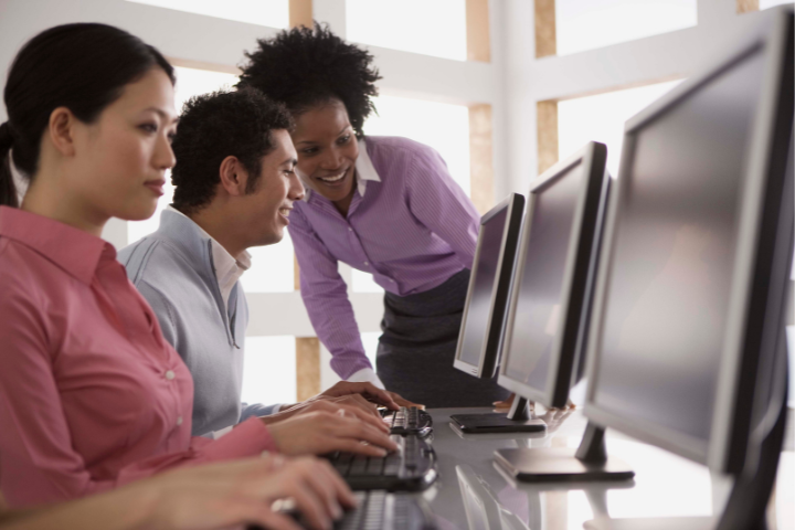 Three people working at computers.