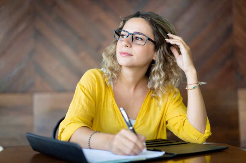 woman writing and contemplating 