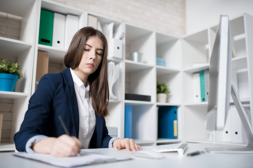 business woman sitting at her desk applying editing skills for managers