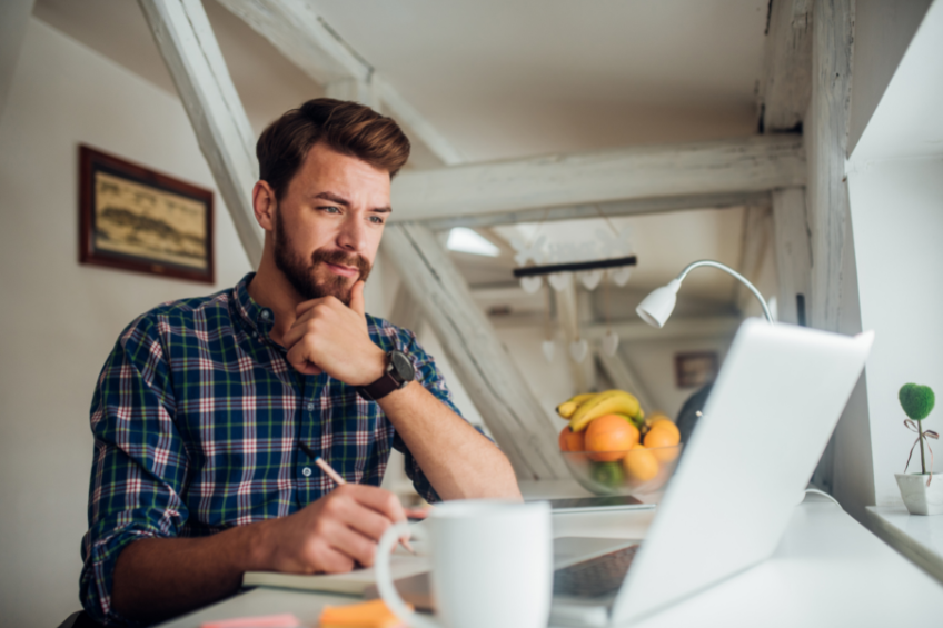 a man sitting at his desk writing content on his computer