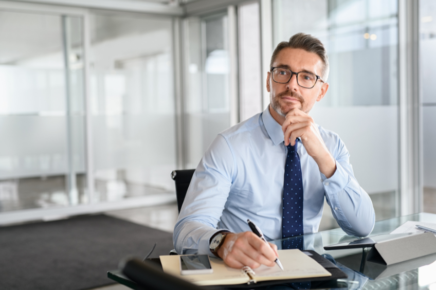 man in a suit sitting at a desk withhis right hand on his chin thinking about how to best refine his closing statment