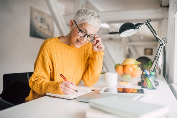 A person sitting at a desk writing in a notebook.