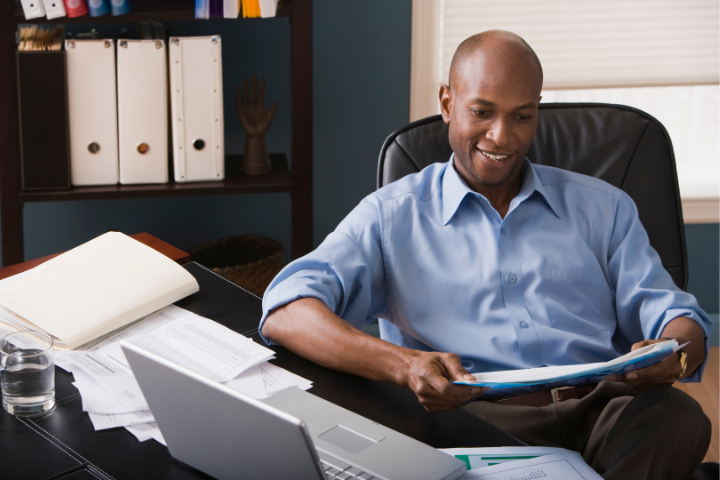 A person sitting at their desk reading a document.