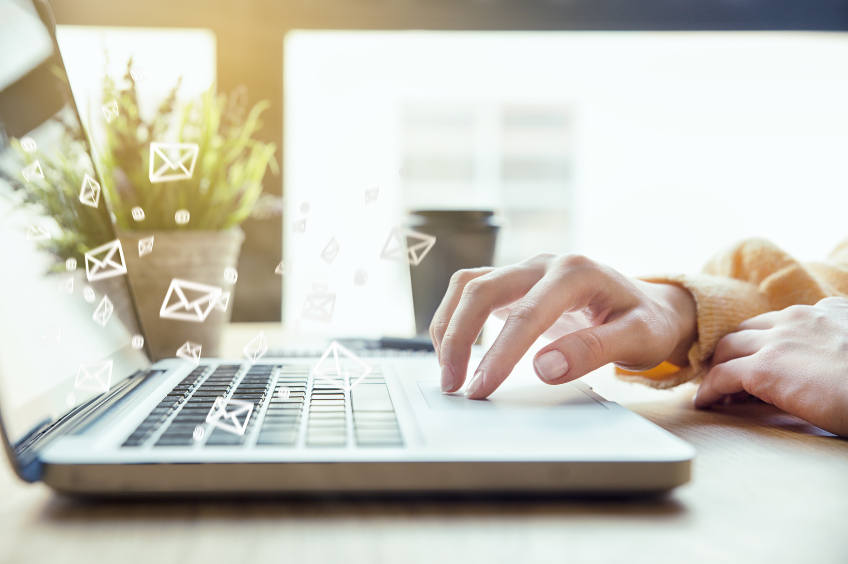 zoomed in image of a womans hands typing on a computer paying attention to email etiquette